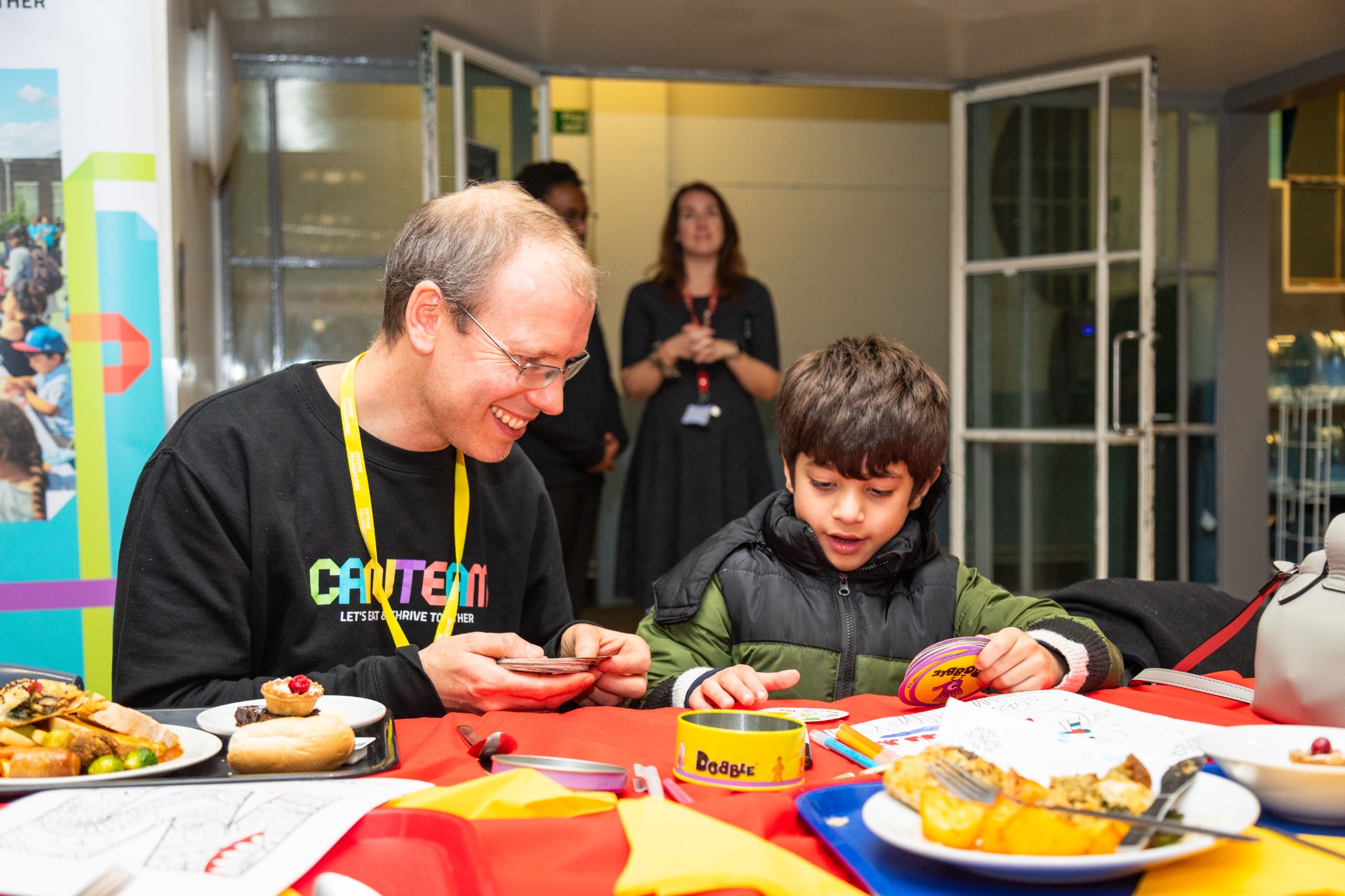 Families of different ages talking together around a CanTeam table